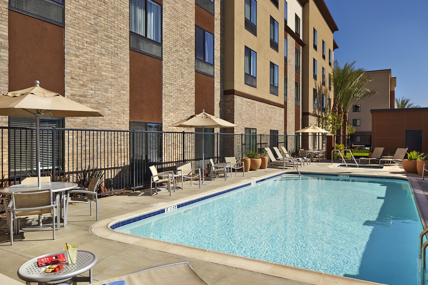 Outdoor pool with loungers and umbrellas at Hilton Garden Inn Los Angeles/Redondo Beach